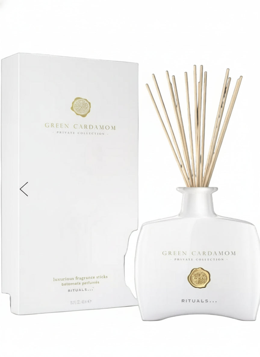 White diffuser with reeds and packaging on a black background